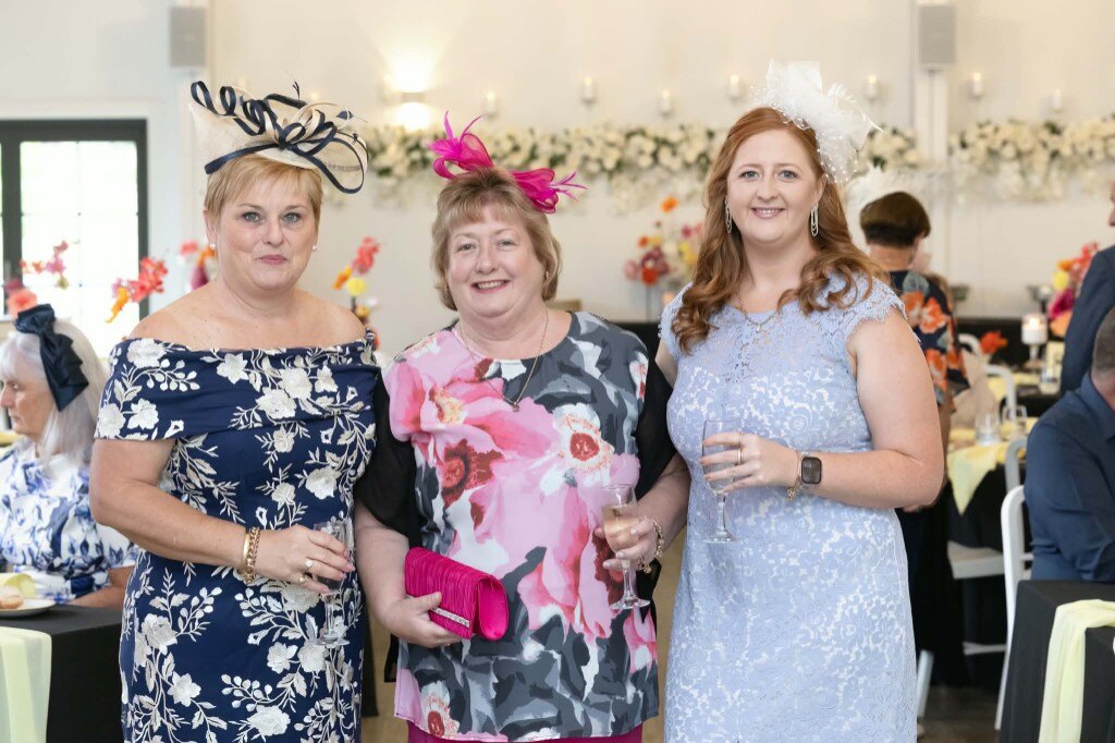 Friends in race-day fascinators toasting with champagne