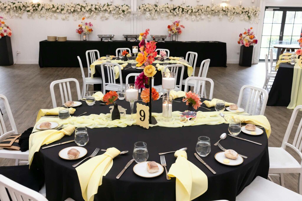 Elegant black and lemon table setting with floral centrepiece ready for luncheon
