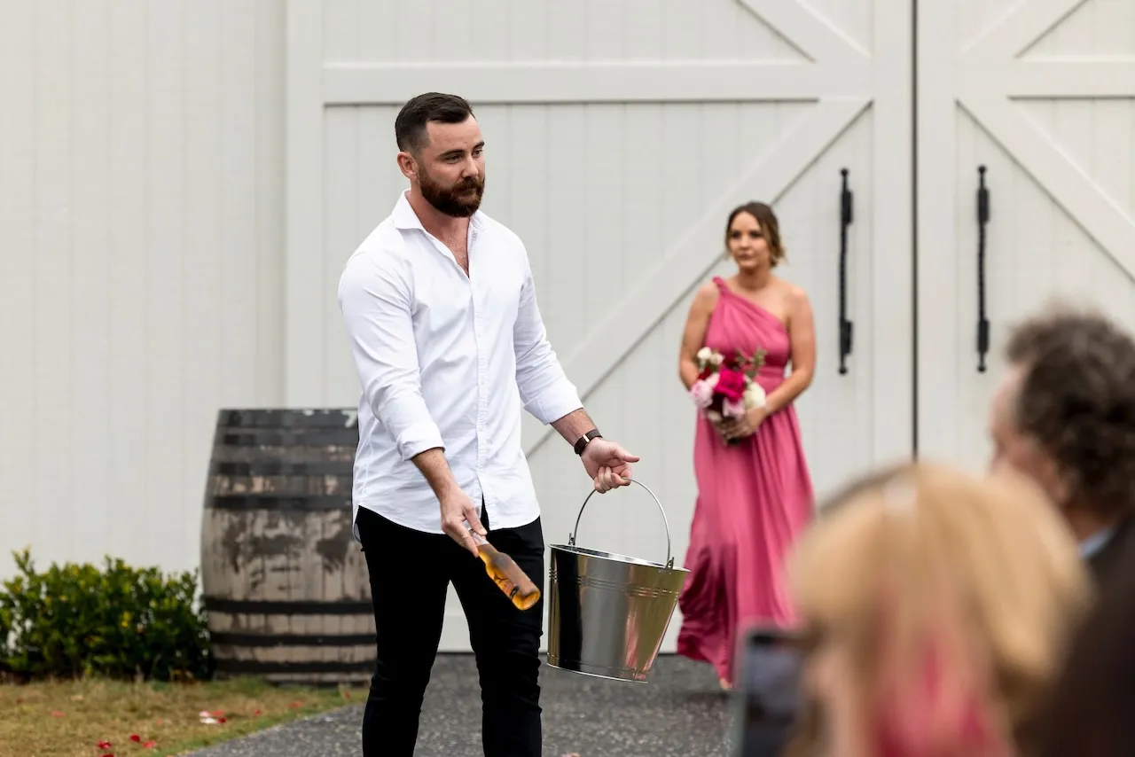 Photo of a bearded male handing out bottled beers from an ice bucket