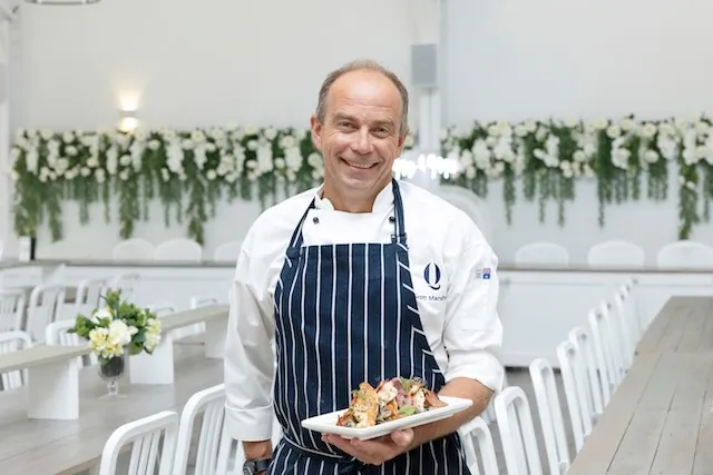 A skilled chef preparing delicious food in the kitchen at White Barn Pokolbin.