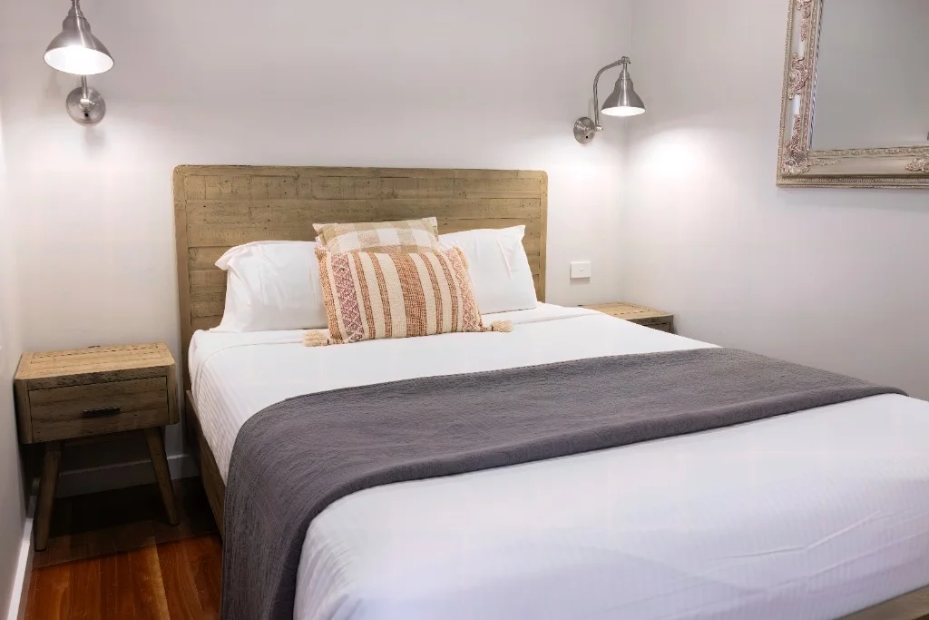 Guest house bedroom with rustic timber headboard