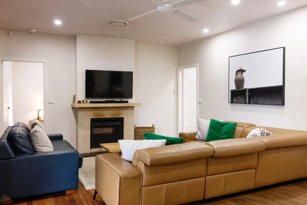 Guest house lounge with leather seating and fireplace