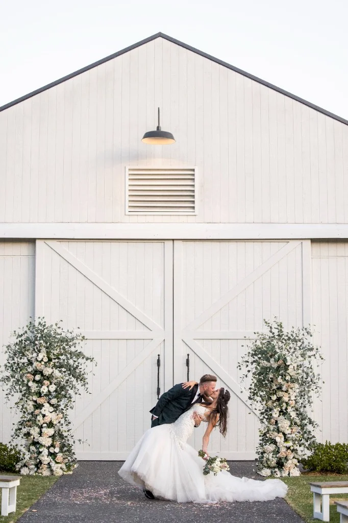 Bride and groom kissing outside the White Barn at White Barn Pokolbin Hunter Valley wedding venue