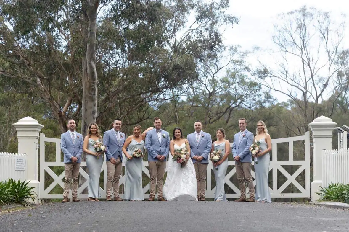 Brides Maids and Groomsmen posing for photo in front of entrance gates at The White Barn Pokolbin