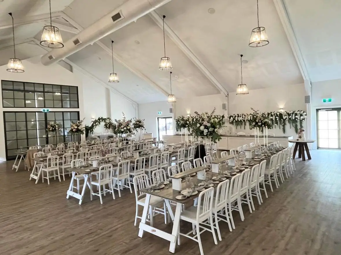 Interior image of the White Barn Pokolbin featuring tables, chairs and florals