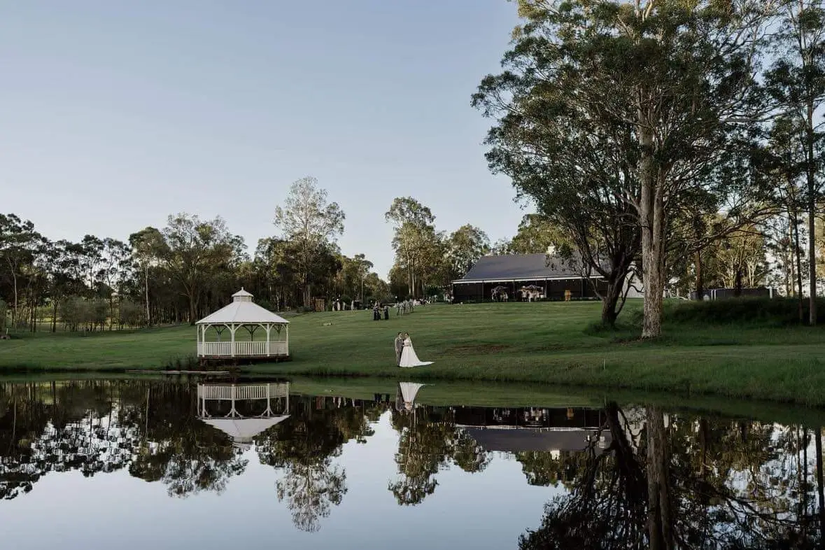 Scenic image of the pond, outdoor pavilion looking up at the exterior of the White Barn Pokolbin