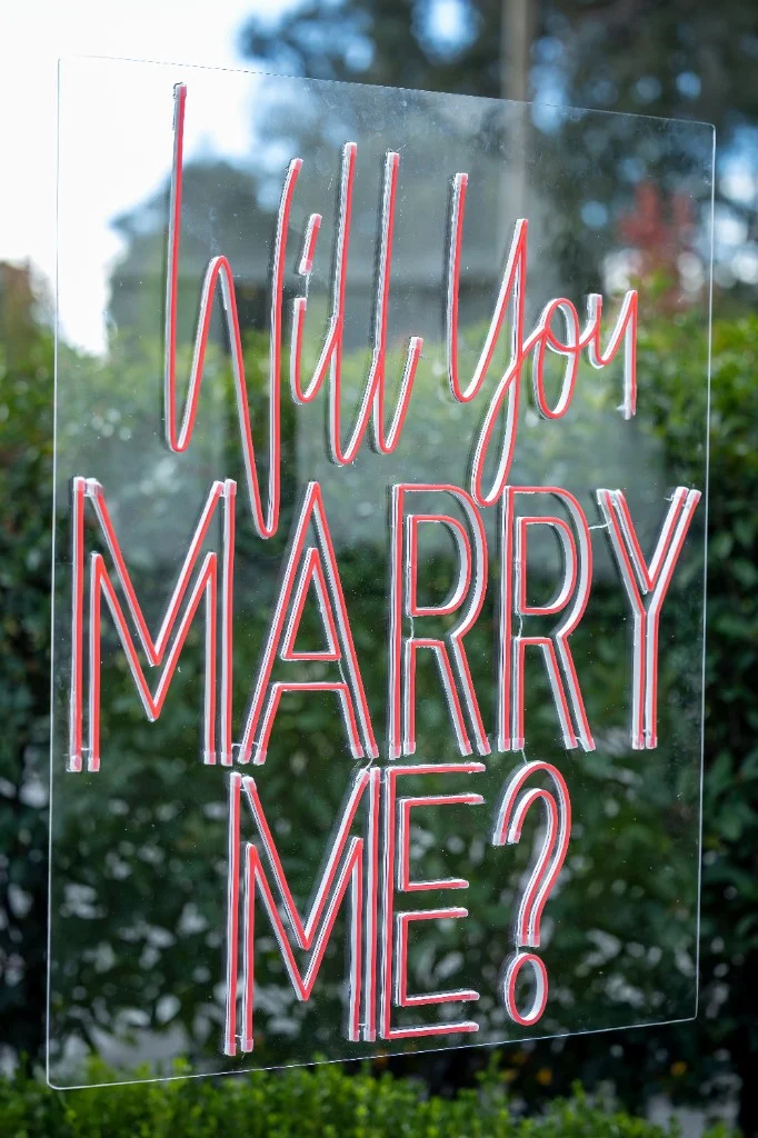 Neon Will You Marry Me sign on clear acrylic backing